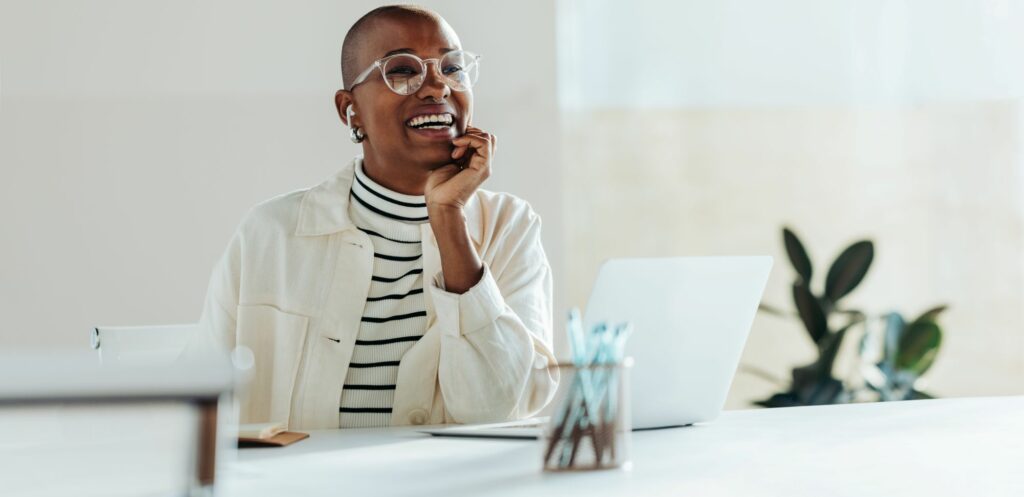 Lady sitting a desk laughing