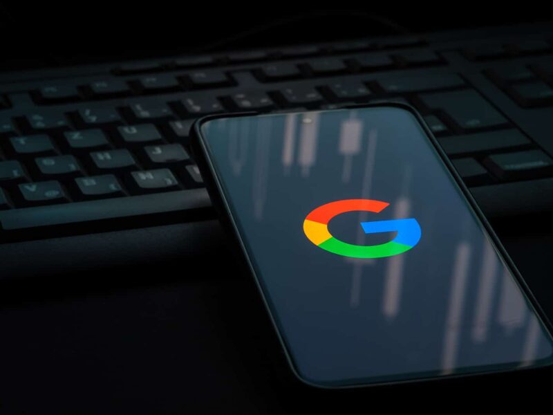 A dark phone and keyboard with the Google logo on smartphone screen