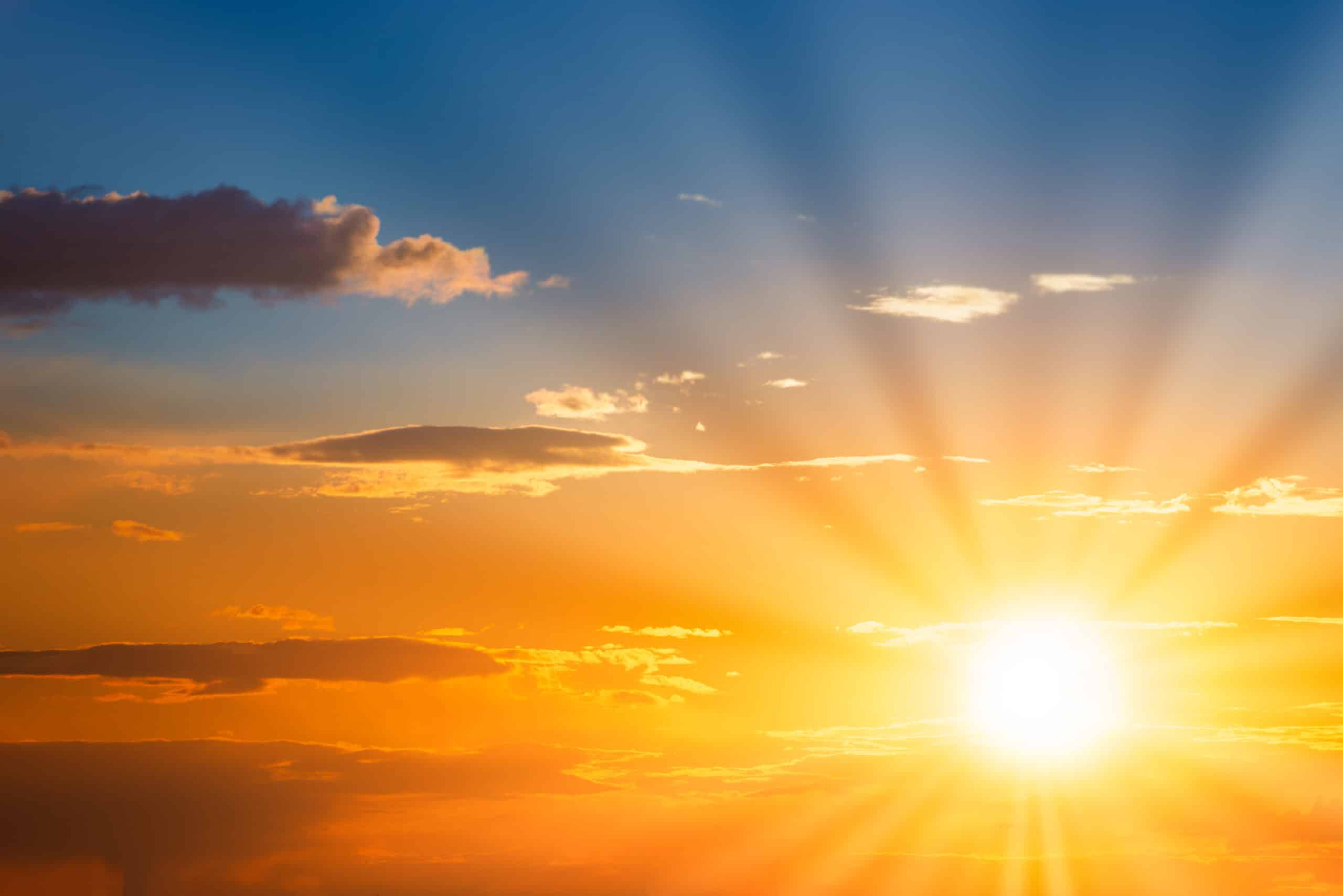 Sun rays on sunset sky with blue ond orange colorlul sunset clouds