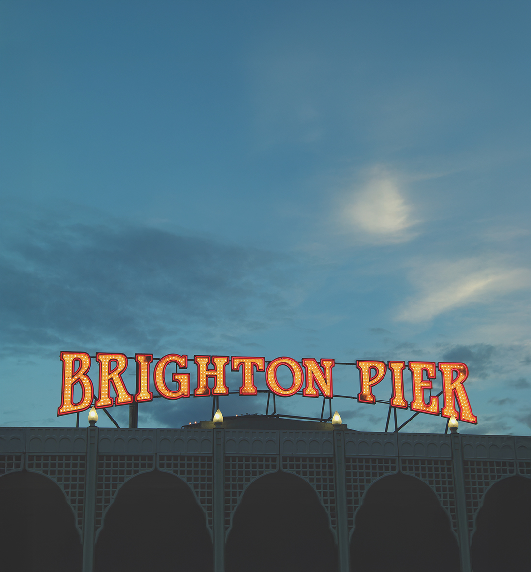 Dusk image of lighted lettering spelling out "brighton pier" from Brighton Pier