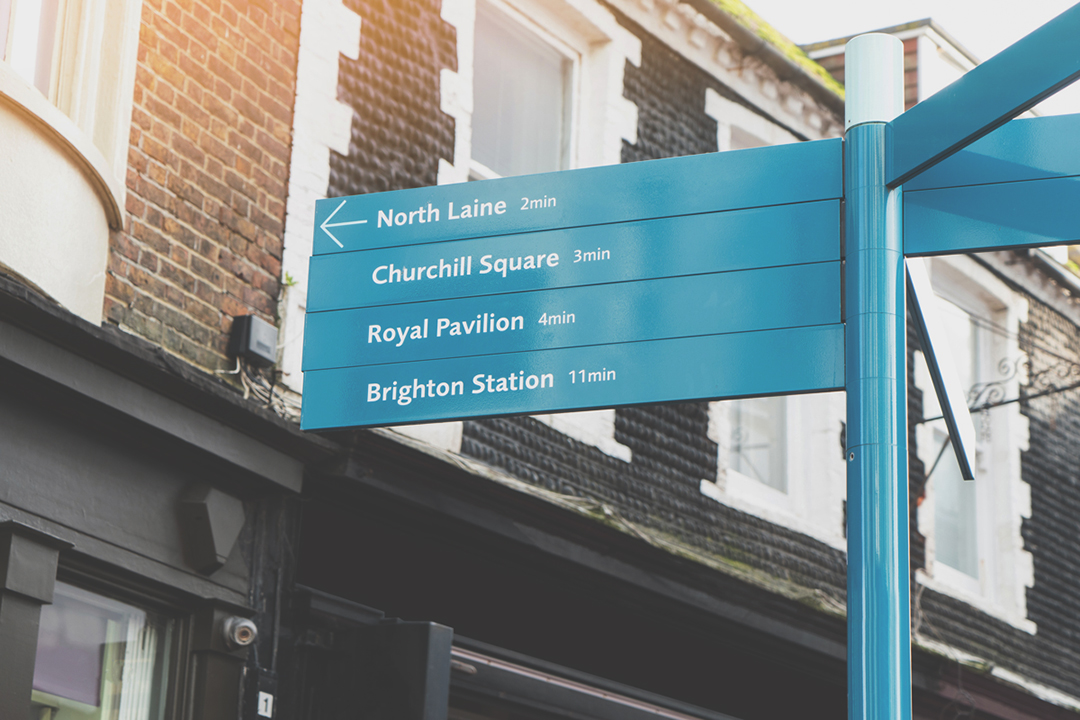 Blue signpost in Brighton highlighting several local attractions