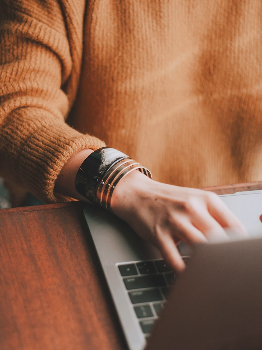 Woman sitting at desk on laptop searching the web.