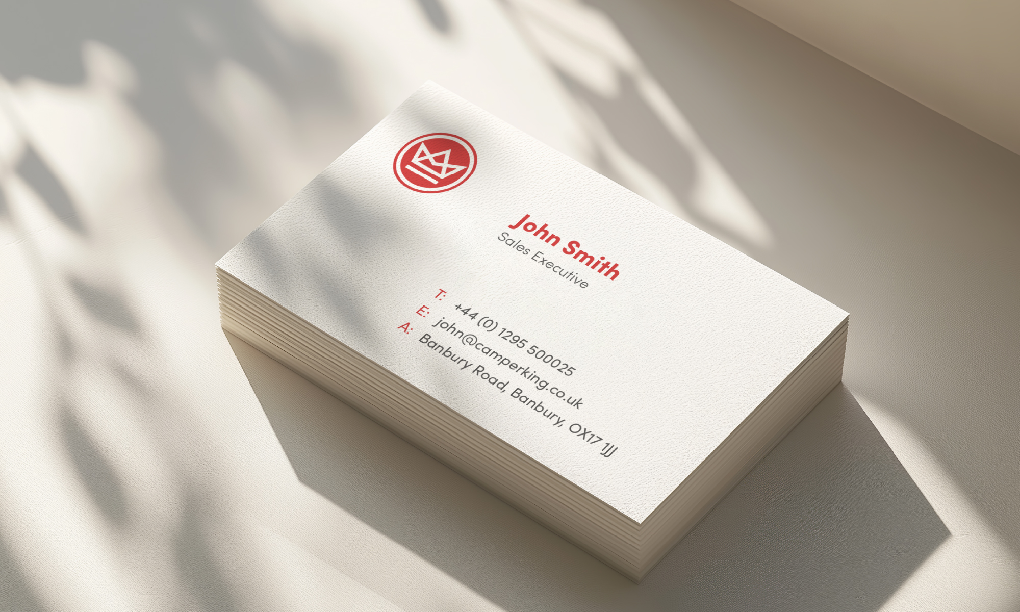 A stack of Camperking business cards with light reflecting on them