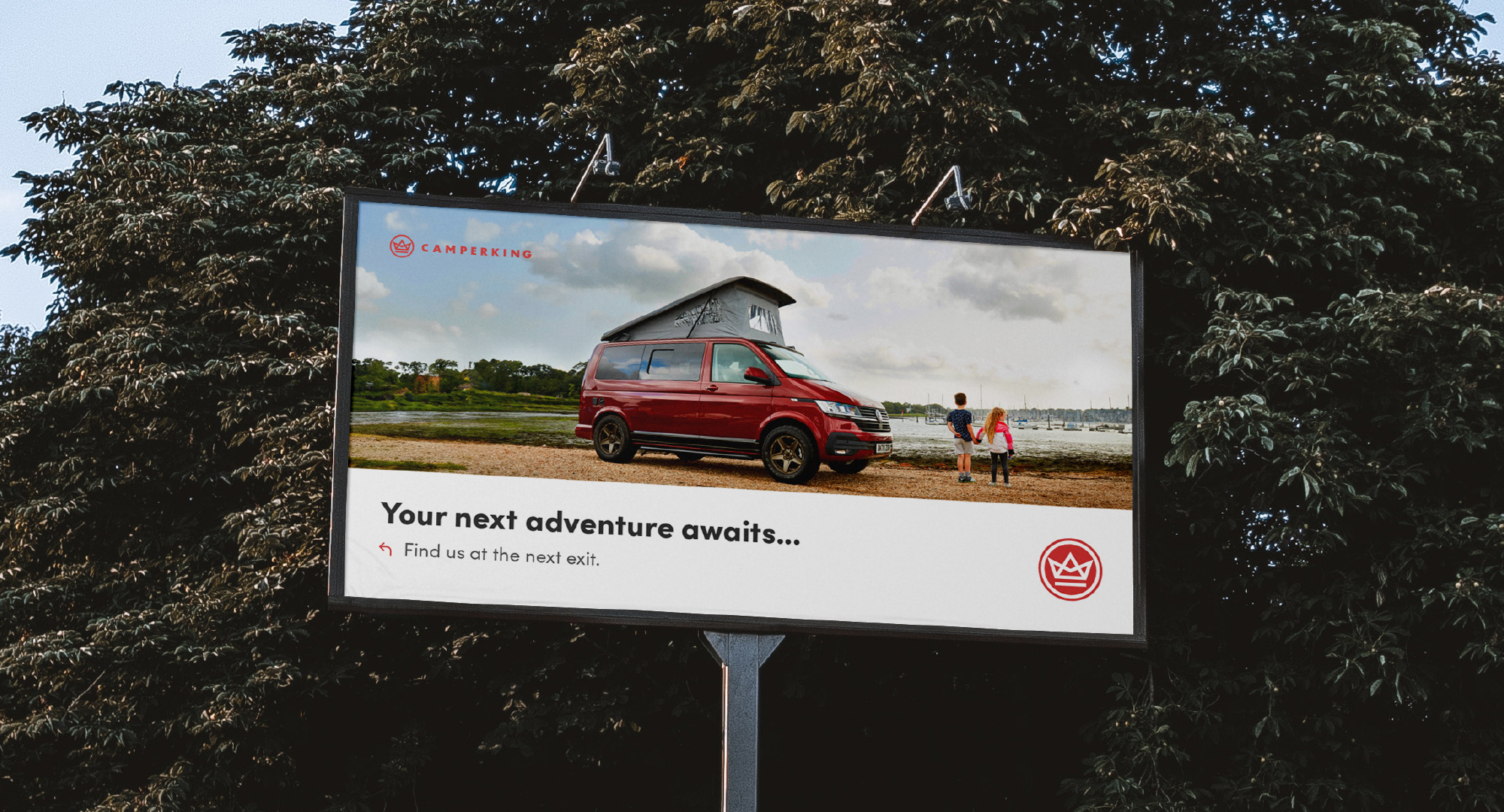a camperking billboard with trees in the background