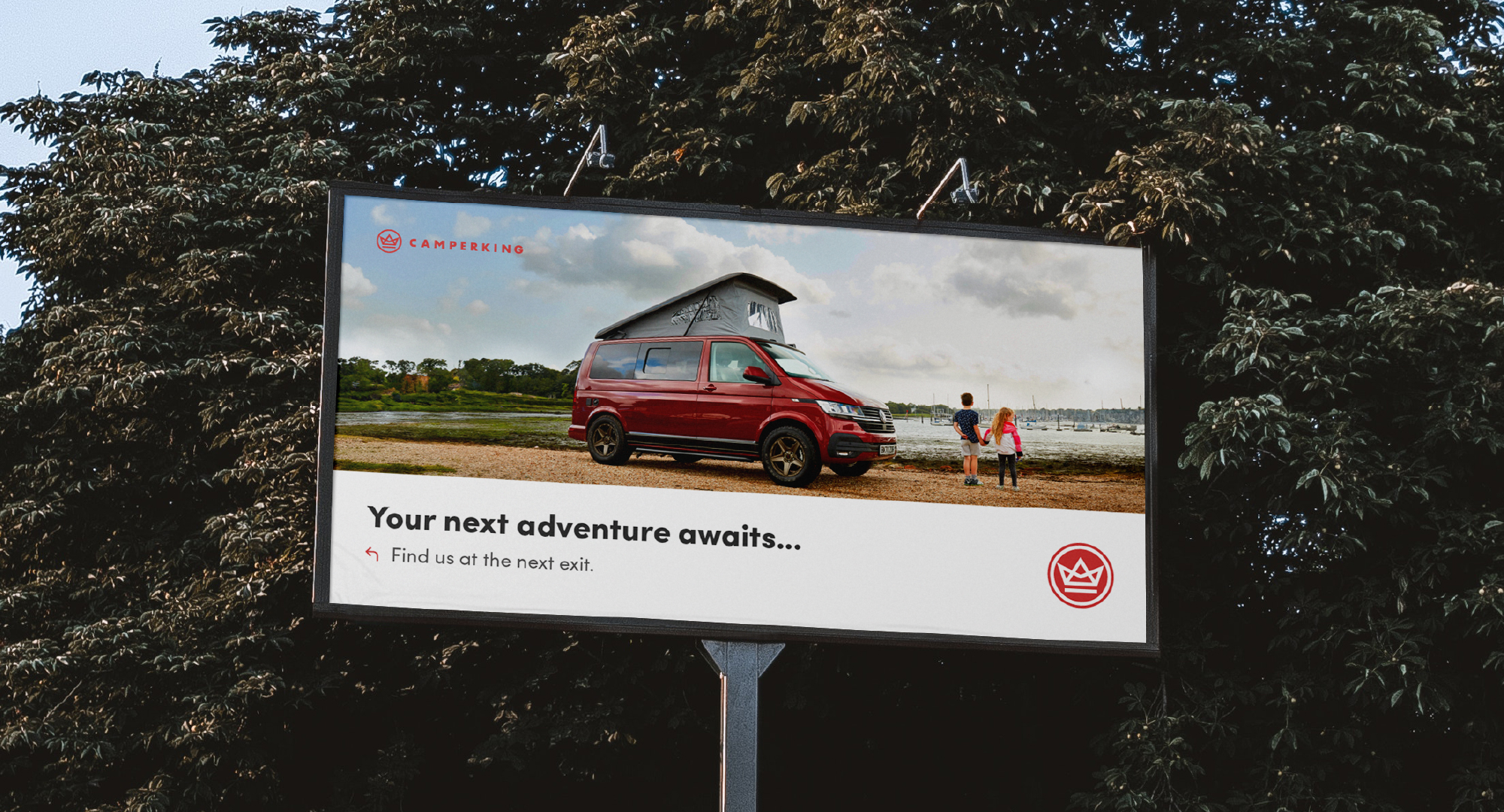a camperking billboard with trees in the background