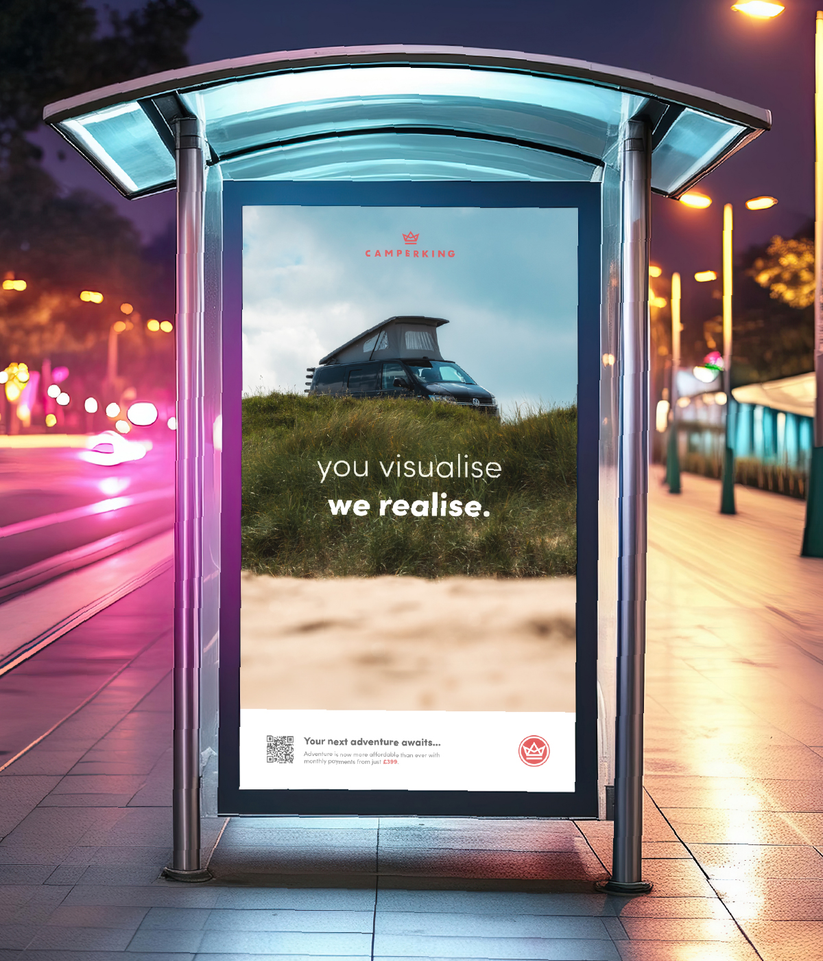 A bus stop at night with a Camperking advertisement light up on the side of it