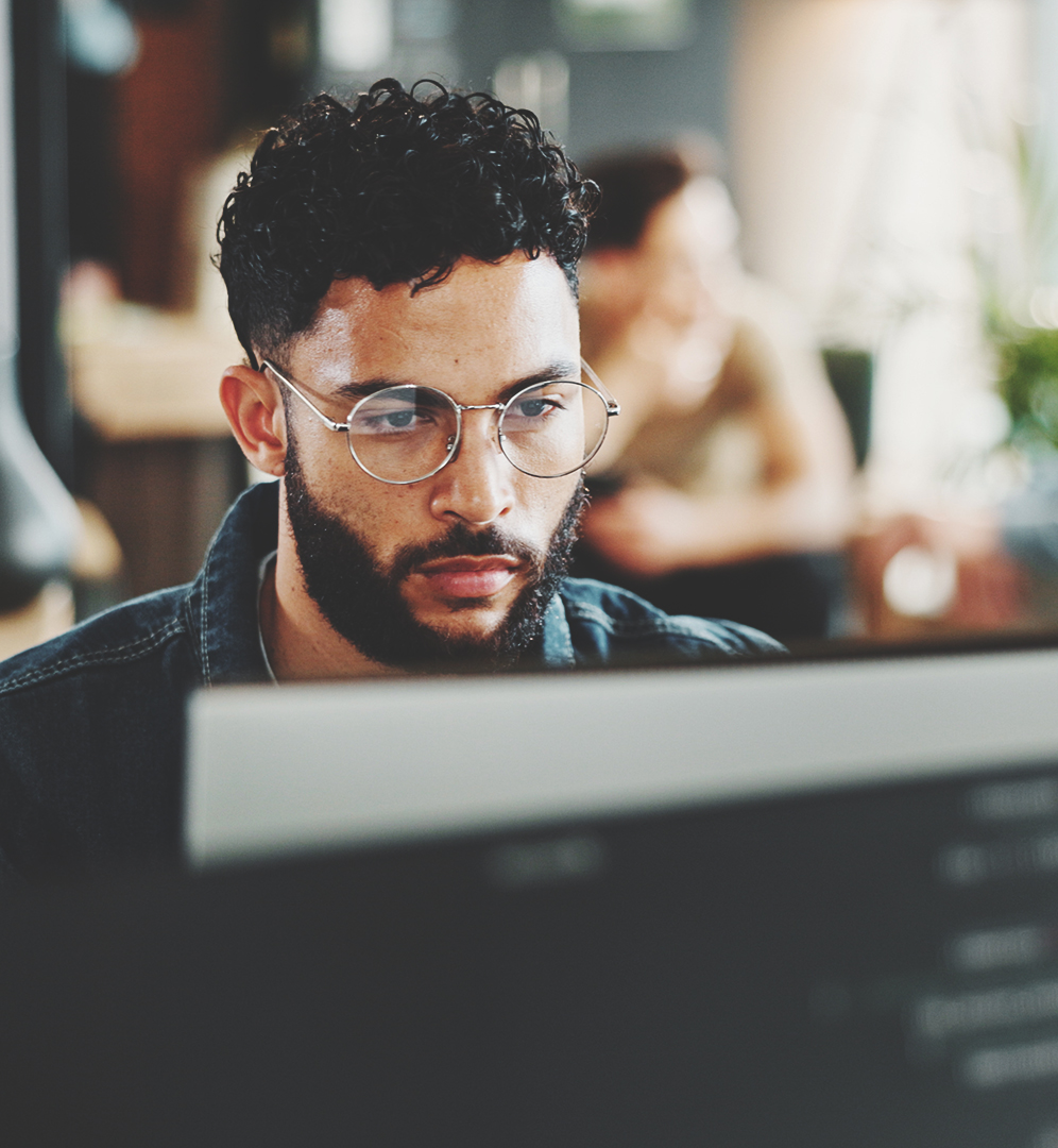 man focused on his laptop as he works on web maintenance tasks
