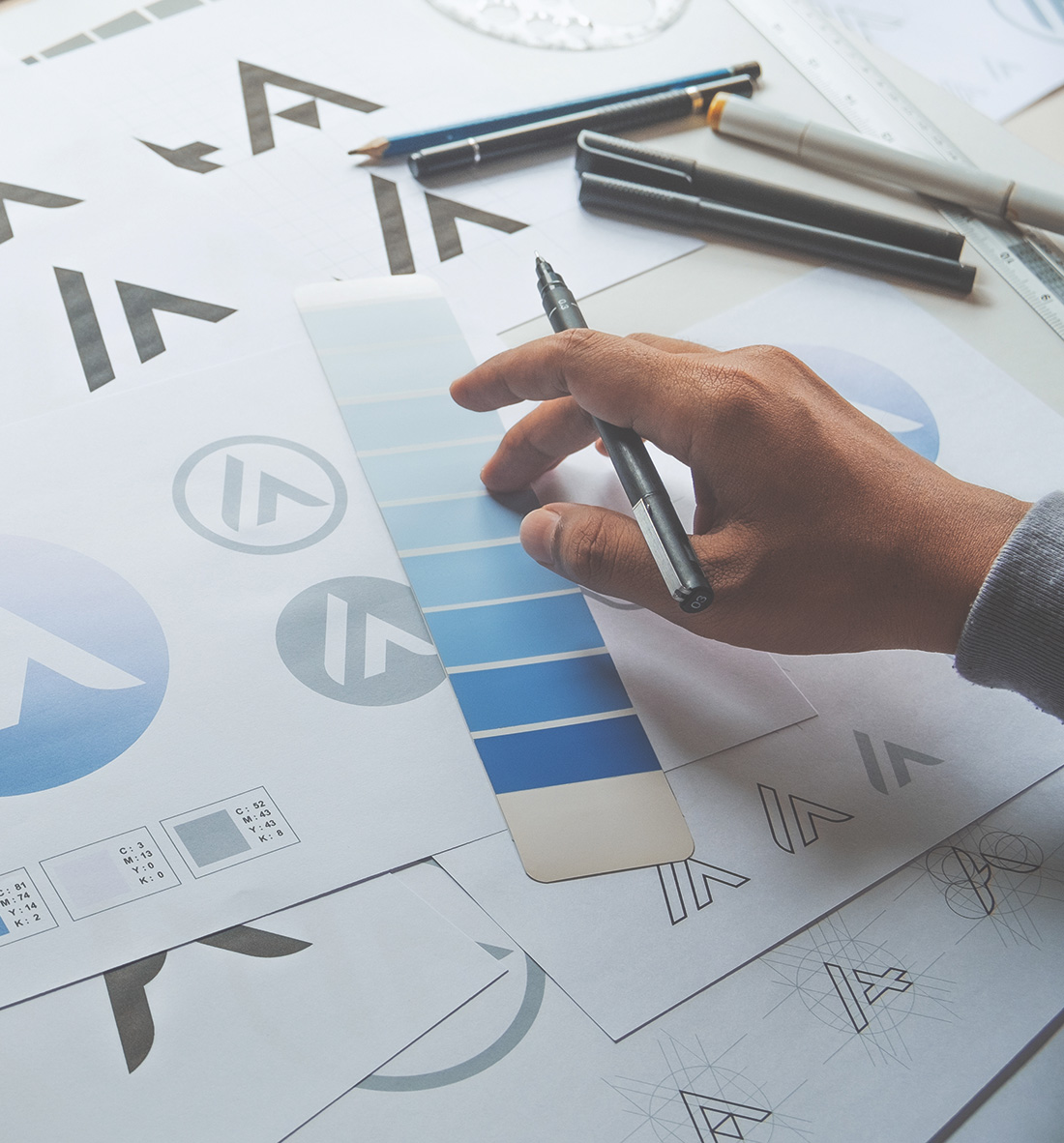 image of a branding logo design process with sketches, colour swatch and guidelines