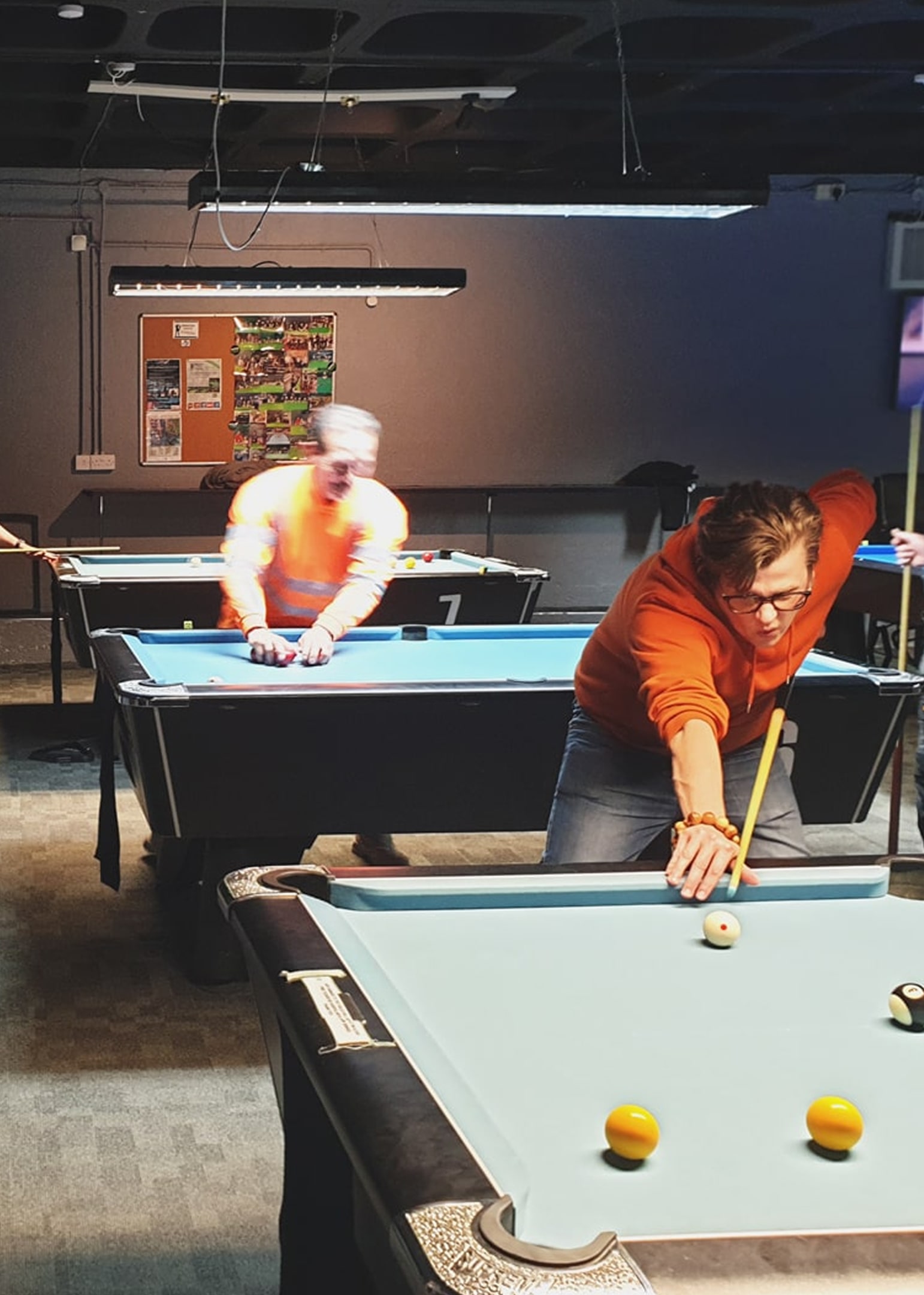 a member of the web development team playing pool at a local pool hall