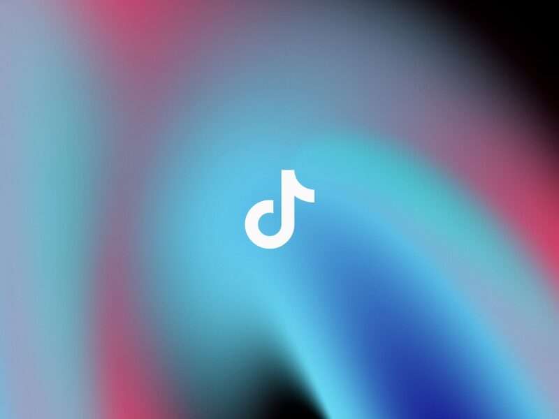Gradient swirl of blue, pink and black representing TikTok brand colours with TikTok white logo in center