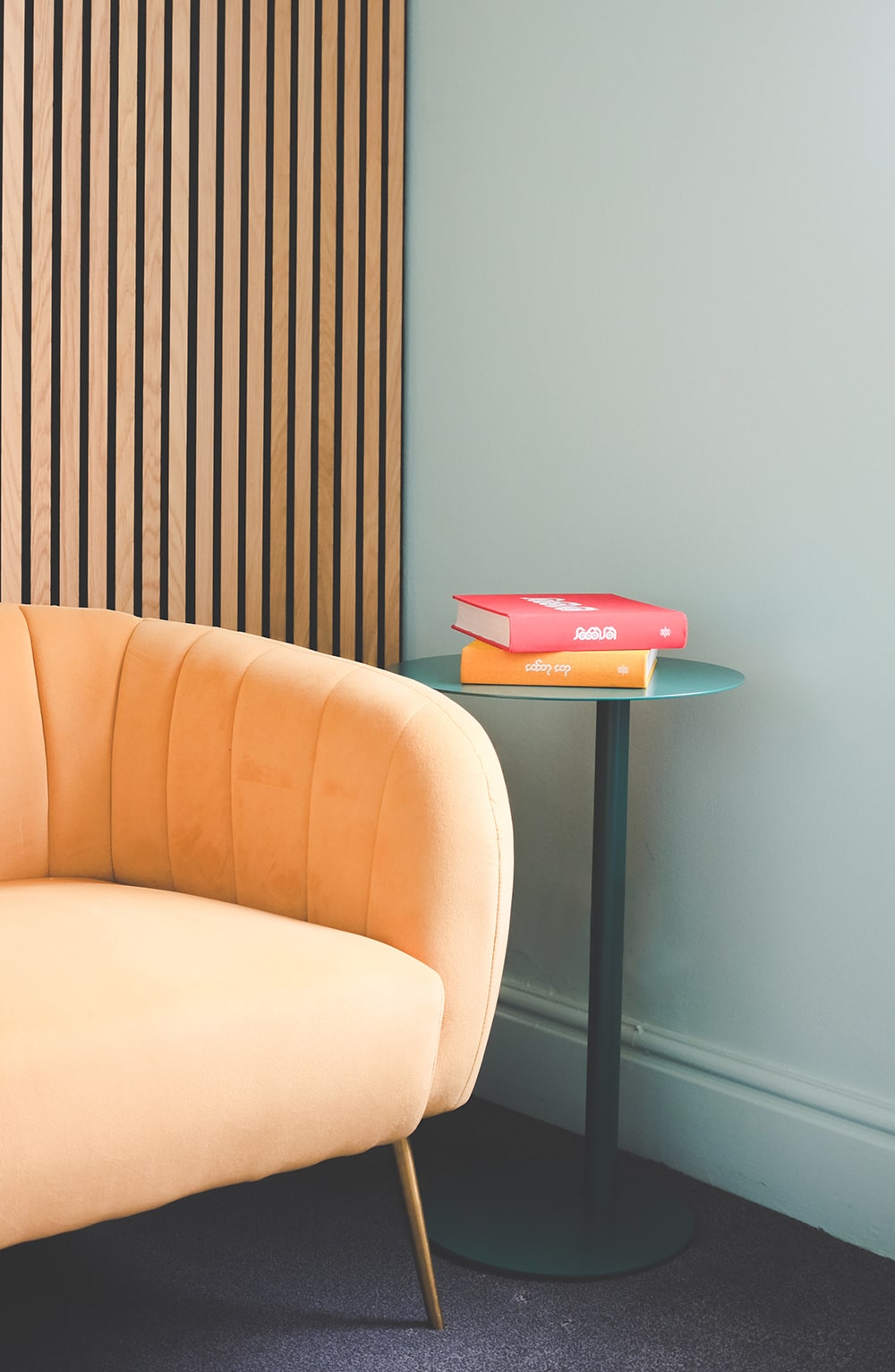 angled picture of couch next to a small table of books besides it in bamboo nine's office