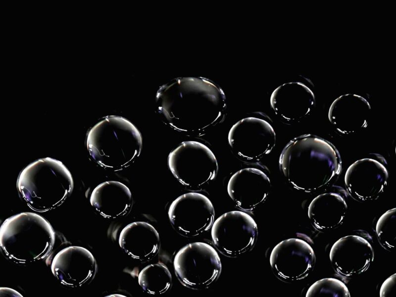 Transparent bubbles floating against a dark background, symbolising the potential burst of the AI technology bubble