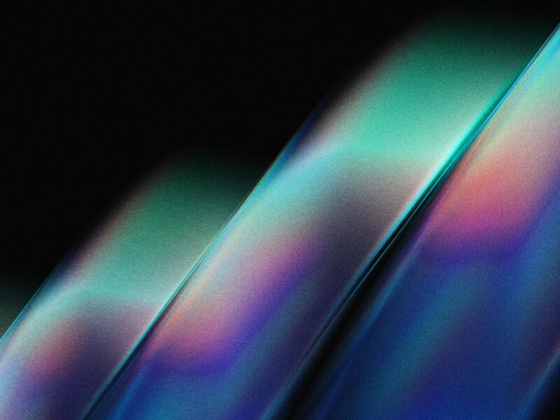 Abstract digital background with soft, flowing bands of iridescent blue, teal, purple, and pink light on a dark backdrop.