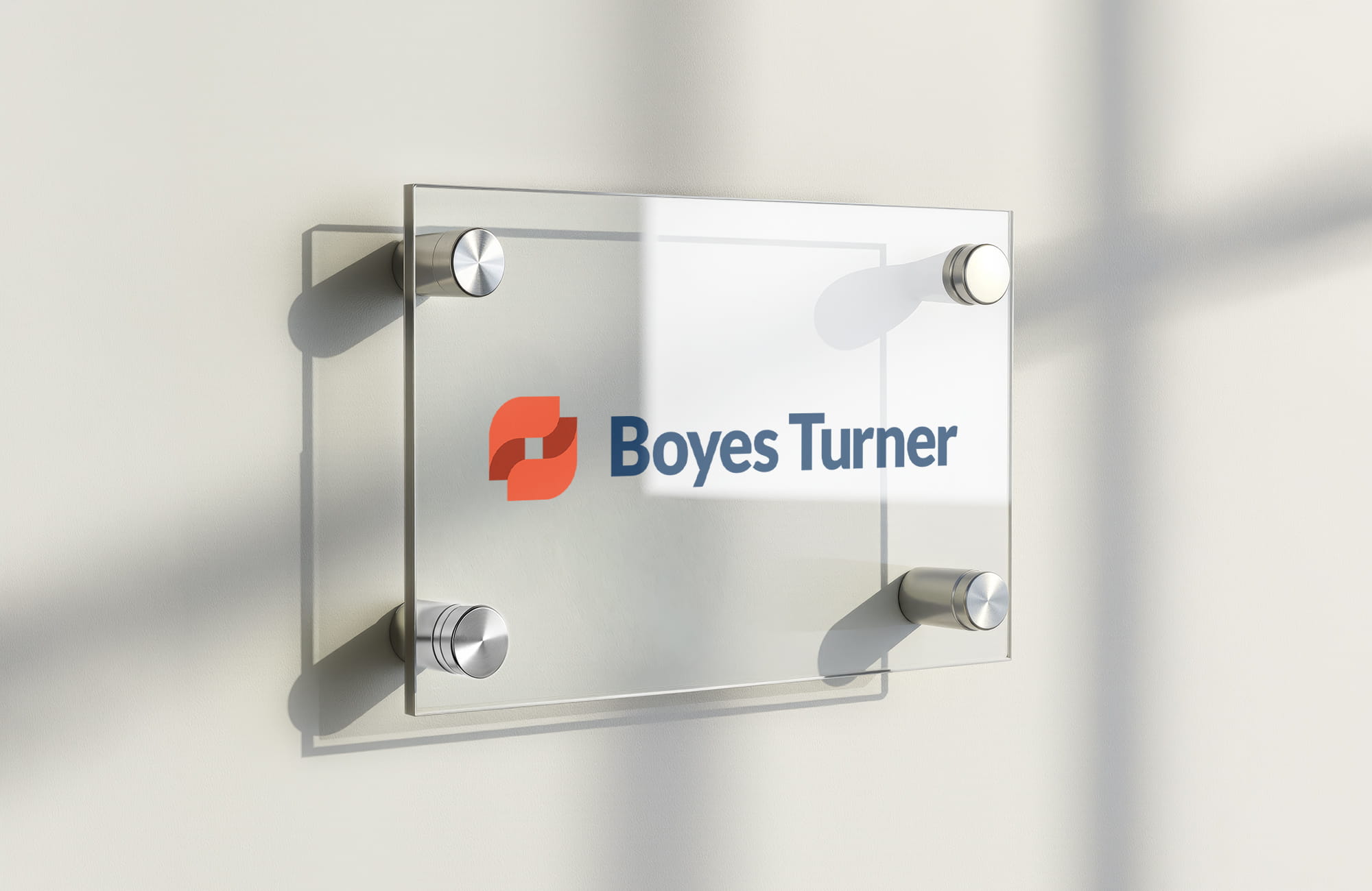 Glass sign with the Boyes Turner logo mounted on a wall.