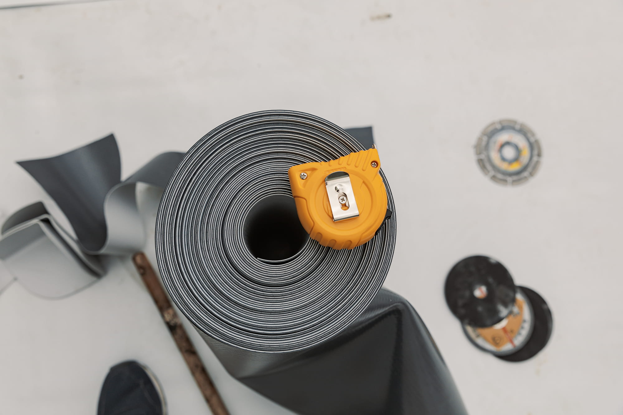 Roll of rubber membrane with measuring tape on top.
